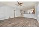 Spacious living room with wood-look floors, ceiling fan, staircase, and an open view of the kitchen at 3510 Brook Crossing Dr, Brandon, FL 33511