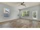 Light-filled living room with neutral walls, wood-look floors, ceiling fan, and several windows at 3510 Brook Crossing Dr, Brandon, FL 33511