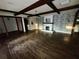Spacious living room featuring hardwood floors, a fireplace, and exposed ceiling beams at 3521 Sumner Rd, Dover, FL 33527