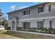 Charming two-story townhouse featuring a well-maintained lawn and gray shutters at 4049 Dolphin Dr, Tampa, FL 33617