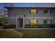 Charming two-story townhouse featuring a well-maintained lawn and gray shutters at dusk at 4049 Dolphin Dr, Tampa, FL 33617