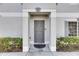 A welcoming gray front door with modern details and manicured shrubbery at 4049 Dolphin Dr, Tampa, FL 33617