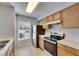 Kitchen with stainless steel appliances, tile floors, wood cabinets and natural light at 4049 Dolphin Dr, Tampa, FL 33617