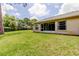Spacious backyard featuring a lush green lawn and a screened-in porch, perfect for outdoor enjoyment at 4908 Lynchburg Ct, New Port Richey, FL 34655