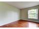 Bedroom with wood floors, light-colored walls, and a bright window at 4908 Lynchburg Ct, New Port Richey, FL 34655