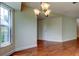 Bright dining area featuring hardwood floors, a modern chandelier, and natural light at 4908 Lynchburg Ct, New Port Richey, FL 34655