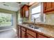 Kitchen features granite counters, a double sink, cabinets, and a bright window at 4908 Lynchburg Ct, New Port Richey, FL 34655