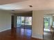 Open-concept living room with hardwood floors and access to the kitchen and lanai at 4908 Lynchburg Ct, New Port Richey, FL 34655