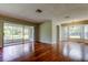 Spacious living room featuring hardwood floors, a screened patio, and lots of natural light at 4908 Lynchburg Ct, New Port Richey, FL 34655