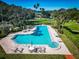Aerial view of a large pool with a hot tub and plenty of lounge chairs surrounded by mature landscaping at 504 S Florida Ave # 225, Tarpon Springs, FL 34689