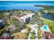 Overhead view of an apartment building with a pool, palm trees, landscaping, and bay in background at 504 S Florida Ave # 225, Tarpon Springs, FL 34689
