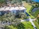 Aerial view of an apartment building with beautiful landscaping and a long drive way at 504 S Florida Ave # 225, Tarpon Springs, FL 34689
