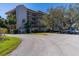 Exterior view of an apartment building with a tiled roof and balconies near parking at 504 S Florida Ave # 225, Tarpon Springs, FL 34689