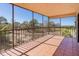 A sunlit, screened balcony with tile floor and a pleasant view of nearby greenery and a golf course at 504 S Florida Ave # 225, Tarpon Springs, FL 34689