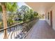 Spacious balcony with tiled floors and wrought iron railings, offering serene views of lush landscaping at 504 S Florida Ave # 225, Tarpon Springs, FL 34689