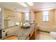 A bathroom featuring double sinks, granite countertop, tiled walls, and ample lighting at 504 S Florida Ave # 225, Tarpon Springs, FL 34689
