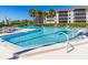 Inviting community pool with clear blue water, lounge chairs, and surrounding green landscape at 504 S Florida Ave # 225, Tarpon Springs, FL 34689