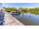 Close-up of the private boat dock, with a boat docked, and calm water reflecting the scenery at 504 S Florida Ave # 225, Tarpon Springs, FL 34689