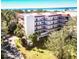 Beautiful condo building with multiple floors, balconies, and lush tropical landscaping at 504 S Florida Ave # 225, Tarpon Springs, FL 34689