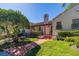Charming home exterior featuring a pergola, lush landscaping, and a red brick pathway at 504 S Florida Ave # 225, Tarpon Springs, FL 34689