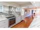 Open concept kitchen with white cabinets, stainless steel appliances, stone counters, and hardwood floors at 504 S Florida Ave # 225, Tarpon Springs, FL 34689