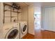 Laundry area with washer, dryer, and wire shelves is located near the entrance to the living room at 504 S Florida Ave # 225, Tarpon Springs, FL 34689