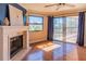Living room features a fireplace, hardwood floors, a ceiling fan, and sliding glass doors to a balcony at 504 S Florida Ave # 225, Tarpon Springs, FL 34689