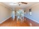 Large living room with hardwood floors, light fixtures, kitchen access, and a large window at 504 S Florida Ave # 225, Tarpon Springs, FL 34689