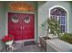 Close-up of the red double front doors, adorned with wreaths and complemented by flowers at 5501 Stag Thicket Ln, Palm Harbor, FL 34685