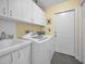 Functional laundry room offers cabinetry, sink and modern washer and dryer for convenience at 5501 Stag Thicket Ln, Palm Harbor, FL 34685