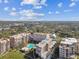 Aerial shot of condo building, green spaces, swimming pool, and a tree-filled neighborhood at 620 Edgewater Dr # 204, Dunedin, FL 34698