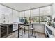 Bar area with wine refrigerator, bar, and a window overlooking the community and pool at 620 Edgewater Dr # 204, Dunedin, FL 34698