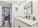 Bright bathroom with marble countertops, white cabinets, and views to bedroom at 620 Edgewater Dr # 204, Dunedin, FL 34698