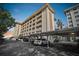 Multi-story building features covered parking, multiple balconies, and lush landscaping at 620 Edgewater Dr # 204, Dunedin, FL 34698