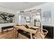 Open dining area with wood table, bench seating, modern light fixture, and stylish art at 620 Edgewater Dr # 204, Dunedin, FL 34698