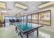 Game room with a ping pong table and large windows offering outdoor views at 620 Edgewater Dr # 204, Dunedin, FL 34698