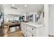Kitchen island with marble countertop adjacent to a dining area with wood floors at 620 Edgewater Dr # 204, Dunedin, FL 34698