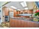 Well-lit kitchen with wooden cabinetry, granite countertops and stainless steel appliances at 620 Edgewater Dr # 204, Dunedin, FL 34698