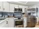 Kitchen featuring stainless steel appliances, white cabinets, and stylish backsplash at 620 Edgewater Dr # 204, Dunedin, FL 34698