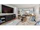 Stylish living room open to kitchen and dining room, with hardwood flooring and large screen TV at 620 Edgewater Dr # 204, Dunedin, FL 34698