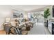 Bright living room with couch, hardwood floors, art, bar area, and a window with a view at 620 Edgewater Dr # 204, Dunedin, FL 34698