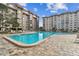 Gorgeous community pool and surrounding condo buildings on a sunny day with chairs for lounging at 620 Edgewater Dr # 204, Dunedin, FL 34698