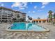 The inviting pool is the central element, flanked by manicured landscaping, lounge chairs and the pool house at 620 Edgewater Dr # 204, Dunedin, FL 34698