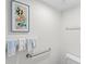 Clean bathroom with a decorative fish print, safety bar, towel rack, and white walls create a simple and functional space at 6311 99Th N Way # 11B, St Petersburg, FL 33708