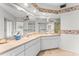 Bright bathroom featuring dual sinks, a large mirror, and seashell-themed wallpaper, offering a refreshing and stylish space at 6311 99Th N Way # 11B, St Petersburg, FL 33708