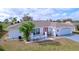 Beautiful single-story home with white brick, a red front door, a well-manicured lawn, and an attached garage at 634 Allegheny Dr, Sun City Center, FL 33573