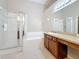 Bathroom features a shower, bath, vanity with tan countertop and tile flooring at 7541 Mariners Harbour Dr, Wesley Chapel, FL 33545