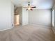 Bright bedroom with a ceiling fan, neutral walls, and carpeted flooring at 7541 Mariners Harbour Dr, Wesley Chapel, FL 33545