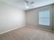 Cozy bedroom with neutral carpet, a ceiling fan, and a bright window at 7541 Mariners Harbour Dr, Wesley Chapel, FL 33545