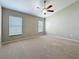 Spacious bedroom with carpet flooring, two windows, and a ceiling fan at 7541 Mariners Harbour Dr, Wesley Chapel, FL 33545